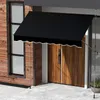 A black awning is installed over a wooden door and window on a wooden-paneled house. Anteprima dell’immagine prodotto
