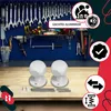 A workshop setting with tools on the wall and two white door knobs on a wooden table. Podgląd zdjęcia produktu