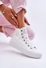 A person's legs and feet wearing white high-top sneakers. Produktbild-Vorschau
