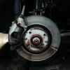 A close-up view of a car's brake assembly, showing the brake disc and caliper. Produktbild-Vorschau