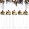 Five clear acrylic flower stands topped with floral arrangements, set against a white background with decorative floral elements in the upper portion. Voir les images du produit