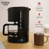A black filter coffee machine is shown on a wooden table next to a steaming mug of coffee. Product specifications are listed on the right side of the image. Podgląd zdjęcia produktu