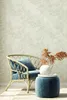 A cozy corner with a wicker chair, blue velvet cushions, and a small side table with decorative items. Podgląd zdjęcia produktu