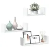 Three white U-shaped shelves are displayed against a white background. The top shelf holds a potted plant. The middle shelf displays three decorative vases. The bottom shelf features two framed pictures and a diffuser with reeds. Voir les images du produit