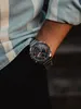 A close-up shot of a person's wrist wearing a Casio Edifice watch, with part of a striped shirt visible. Náhled obrázku produktu