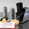 A multi-purpose food grinder with various attachments and shredded cheese in a bowl. Anteprima dell’immagine prodotto