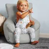 A young child sits in a light gray beanbag chair, holding a wooden toy. Náhľad obrázku produktu