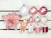 A collection of Christmas ornaments and decorations arranged on a white wooden surface. Náhľad obrázku produktu
