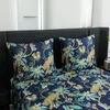 A close-up view of a bed with a duvet cover and two pillows featuring a jungle print with leopards and palm trees. Náhled obrázku produktu