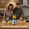 A family is gathered around a kitchen counter with a blender and glasses of smoothie. Produktbild-Vorschau