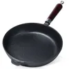 A cast iron frying pan with a wooden handle, shown from a slightly elevated angle against a white background. Podgląd zdjęcia produktu