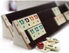 A close-up, angled view of Rummy tiles on racks, with some loose tiles and a die in the foreground. Náhľad obrázku produktu