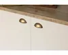 A close-up shot of white cabinet doors with gold cup handles, set against a wooden countertop. Produktbild-Vorschau
