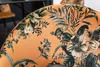 A close-up view of an orange chair with a floral pattern. Produktbild-Vorschau
