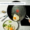 A frying pan with a fried egg being poured onto a plate with food. Anteprima dell’immagine prodotto