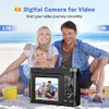 A family is posing for a photo on the beach, with a digital camera in the foreground displaying their image. Produktbild-Vorschau