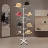 A white hat stand with multiple hats displayed on it, in a retail store setting. Produktbild-Vorschau