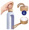 A hand holding a light purple water bottle with a bamboo lid and a braided cord handle. Close-up views of the lid and the bottle's opening are also shown. Náhľad obrázku produktu
