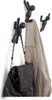 Three black wall hooks shaped like climbing figures are mounted on a white wall. A beige jacket and a black leather bag are hanging on two of the hooks. Náhľad obrázku produktu
