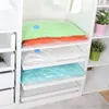 Vacuum sealed bags are neatly stacked on shelves inside a white closet or storage unit. Voir les images du produit