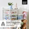A white shelving unit filled with transparent storage boxes containing toys, a plant, and stuffed animals. Overlay text promotes "Smart Store" and product features. Produktbild-Vorschau