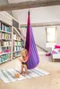 A young girl sits in a purple and pink hanging chair in a room with bookshelves and a bed. Anteprima dell’immagine prodotto