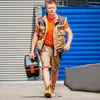 A man walks towards the camera holding a toolbox. Produktbild-Vorschau