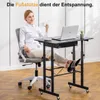 A woman is sitting at a height-adjustable desk with a laptop, holding a cup of coffee, and resting her feet on a footrest. Anteprima dell’immagine prodotto