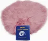 A pink sheepskin seat cushion with a blue product tag in front of it.