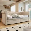 A bedroom scene featuring a beige daybed with storage drawers and a patterned rug. Voir les images du produit
