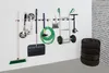 A wall-mounted storage system for garden tools and equipment, with a stack of tires in the foreground. Anteprima dell’immagine prodotto