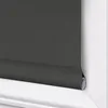 A close-up view of a dark gray roller blind installed in a white window frame. Produktbild-Vorschau