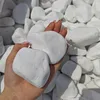 Weiße große Kieselsteine auf einer Handfläche zur Größendarstellung Produktbild-Vorschau