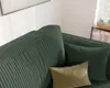 Close-up view of a green corduroy sofa with two pillows. Voir les images du produit
