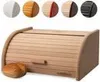 A wooden bread box with a roll-top lid and a single bread roll in front of it. Above the bread box are five circular swatches showing different color options for the product. Produktbild-Vorschau