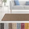A rug in a living room setting with a sofa and side table. Produktbild-Vorschau