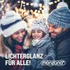 A family in winter clothing smiling in front of blurred Christmas lights. Náhled obrázku produktu