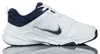 A white Nike shoe with navy blue accents is shown against a white background. Voir les images du produit