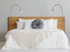 A bedroom scene with a bed, pillows, and lamps. Produktbild-Vorschau