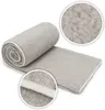 A rolled-up gray blanket with close-up insets showing the texture and edge. Produktbild-Vorschau