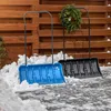 Two snow shovels are placed in snow in front of a wooden fence. Podgląd zdjęcia produktu