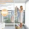 A woman is hanging clothes on a telescopic garment rack on a balcony. Produktbild-Vorschau
