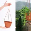 A split image showing an empty hanging planter on the left and a hanging planter with a plant on the right, with a natural background. Produktbild-Vorschau