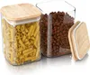 Two glass storage jars with bamboo lids, one filled with pasta and the other with coffee beans. A third lid is placed next to the jars. Produktbild-Vorschau