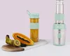 A pastel green and silver mini smoothie maker with a portable bottle and fresh fruit on a marble slab. Produktbild-Vorschau