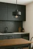A modern kitchen with dark cabinets, subway tile backsplash, and a wooden dining table in the foreground. Náhled obrázku produktu