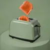 A green toaster with two slices of toast, one popping out. Anteprima dell’immagine prodotto