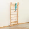 A wooden climbing wall with gymnastic rings hanging from it, mounted on a white wall. Náhľad obrázku produktu