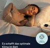 A woman sleeping peacefully in bed, with a device on a nightstand. Anteprima dell’immagine prodotto