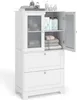 A white wooden bathroom cabinet with two drawers and two doors, one of which is open, revealing shelves with towels and bottles. Podgląd zdjęcia produktu